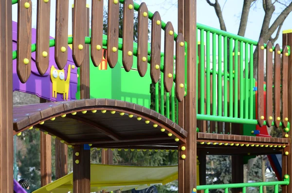 Fragment of a playground made of plastic and wood, painted in different colors