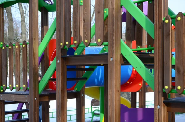 Fragment of a playground made of plastic and wood, painted in different colors