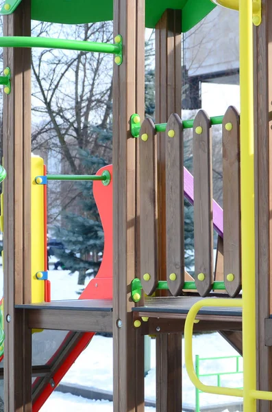 Fragment of a playground made of plastic and wood, painted in different colors