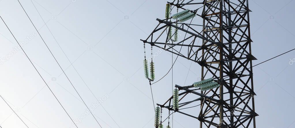 Power lines tower against the blue sky