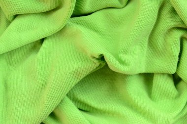 Kumaş dokusuna parlak yeşildir. Gömlek ve bluz yapmak için malzeme