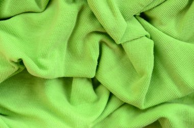 Kumaş dokusuna parlak yeşildir. Gömlek ve bluz yapmak için malzeme