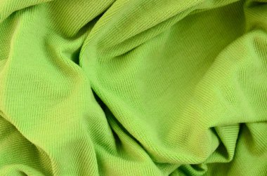Kumaş dokusuna parlak yeşildir. Gömlek ve bluz yapmak için malzeme