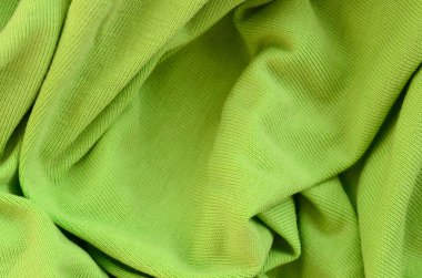 Kumaş dokusuna parlak yeşildir. Gömlek ve bluz yapmak için malzeme