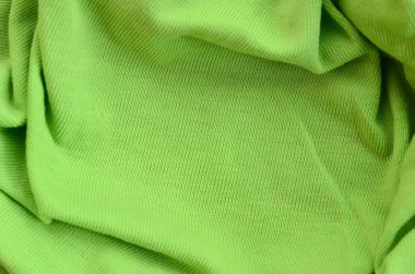 Kumaş dokusuna parlak yeşildir. Gömlek ve bluz yapmak için malzeme