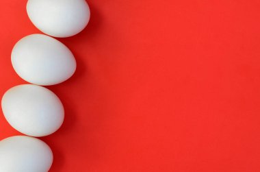 Parlak kırmızı bir arka plan üzerinde bir çok beyaz yumurta
