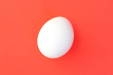 Parlak kırmızı bir arka plan üzerinde bir beyaz yumurta