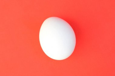 Parlak kırmızı bir arka plan üzerinde bir beyaz yumurta