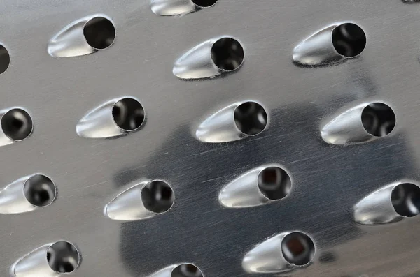 Um fragmento de um ralador de cromo metálico close-up. Textura das lâminas — Fotografia de Stock