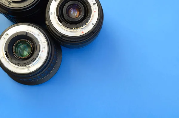 Several photographic lenses lie on a bright blue background. Spa — Stock Photo, Image