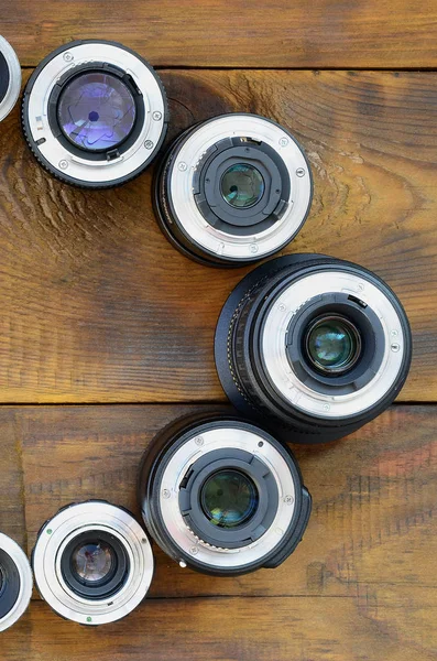 Several Photographic Lenses Lie Brown Wooden Background Space Text — Stock Photo, Image