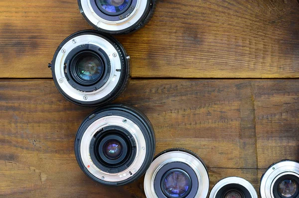 Several Photographic Lenses Lie Brown Wooden Background Space Text — Stock Photo, Image