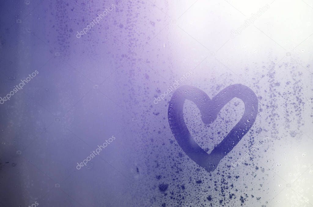 Heart is painted on the misted glass in the winter
