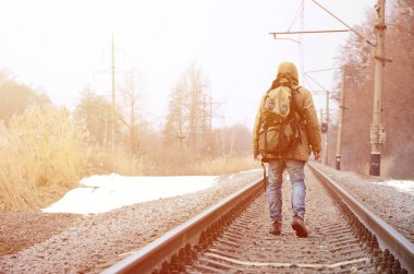 Bir adam büyük bir sırt çantası ile önde kış sezonu boyunca tren yolda gidiyor.