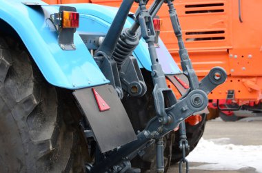 Karlı havada yeni traktörün arka görüntüsü. Tarım aracı arka planı