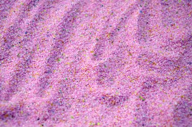Texture of a colored granular sand close up. Pink grains clipart