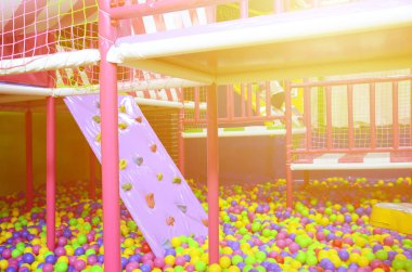 Çocuk parkındaki top havuzunda bir sürü renkli plastik top var.