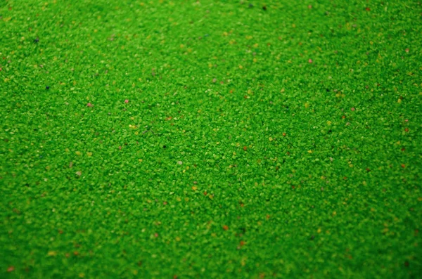 Texture of a colored granular sand close up. Green grains — Stock Photo, Image