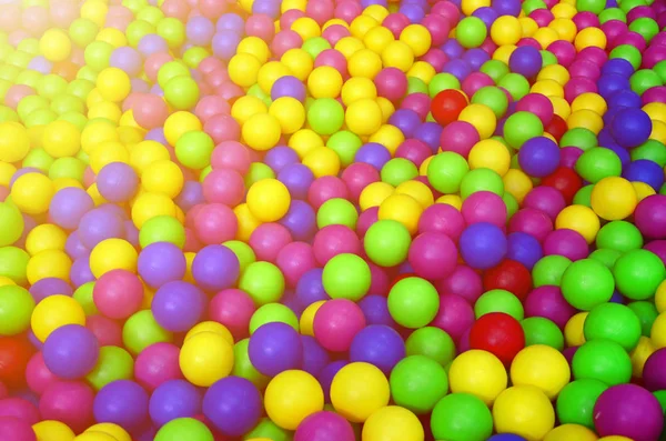 Många färgglada plastbollar i barnens ballpit på en lekplats. — Stockfoto