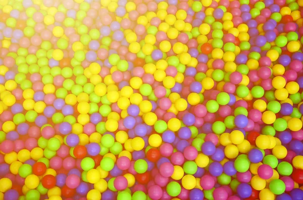 Muitas bolas plásticas coloridas em uma vala infantil em um playground . — Fotografia de Stock