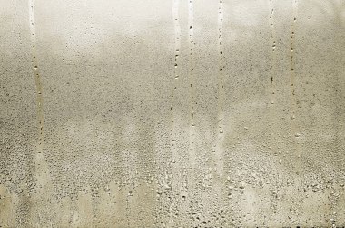 Texture of a drop of rain on a glass wet transparent background. Toned in yellow color clipart