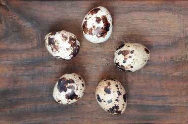 Koyu kahverengi ahşap yüzeyde bıldırcın yumurtaları, üst görüş, metin için boş yer, tarif