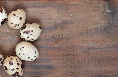 Koyu kahverengi ahşap yüzeyde bıldırcın yumurtaları, üst görüş, metin için boş yer, tarif