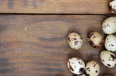 Koyu kahverengi ahşap yüzeyde bıldırcın yumurtaları, üst görüş, metin için boş yer, tarif
