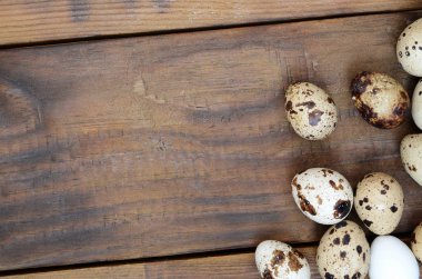 Koyu kahverengi ahşap yüzeyde bıldırcın yumurtaları, üst görüş, metin için boş yer, tarif