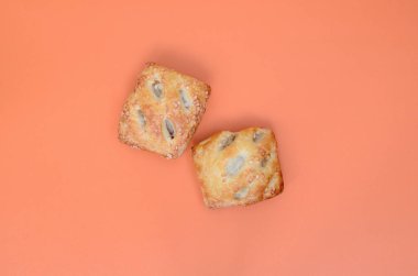 Havadar bir puf böreği ve hassas bir domuz doldurma soğan ile birleştiren bir tatmin et patty. Turuncu bir arka plan üzerinde pişirme