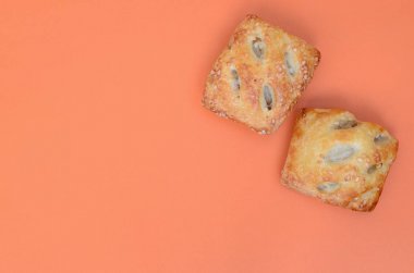 Havadar bir puf böreği ve hassas bir domuz doldurma soğan ile birleştiren bir tatmin et patty. Turuncu bir arka plan üzerinde pişirme
