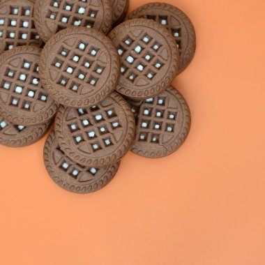 Ayrıntılı resmini koyu kahverengi ile turuncu bir yüzeye doldurma Hindistan cevizi sandviç kurabiye yuvarlak. Çay için birkaç muamele etmek bir close-up arka plan görüntüsü