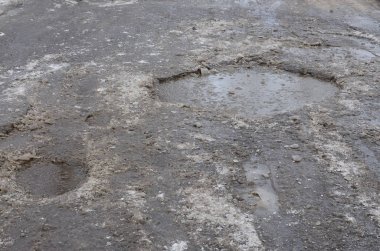 Asfalt yol ile çukurların dondurma ve çözme döngüsü sırasında belgili tanımlık kış nedeniyle zarar görmüş. Zavallı yol