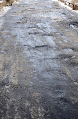 Asfalt yol ile çukurların dondurma ve çözme döngüsü sırasında belgili tanımlık kış nedeniyle zarar görmüş. Zavallı yol