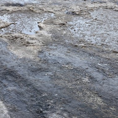 Asfalt yol ile çukurların dondurma ve çözme döngüsü sırasında belgili tanımlık kış nedeniyle zarar görmüş. Zavallı yol