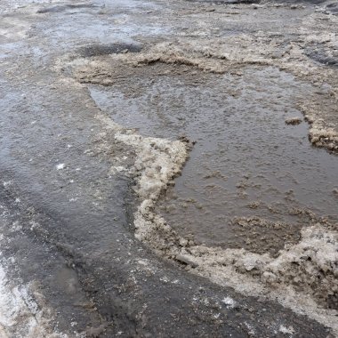 Asfalt yol ile çukurların dondurma ve çözme döngüsü sırasında belgili tanımlık kış nedeniyle zarar görmüş. Zavallı yol