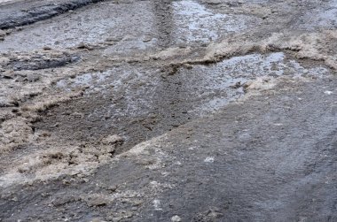 Asfalt yol ile çukurların dondurma ve çözme döngüsü sırasında belgili tanımlık kış nedeniyle zarar görmüş. Zavallı yol