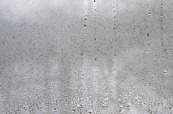 质地的一滴雨在玻璃湿透明的背景上 灰色色调 — 图库照片