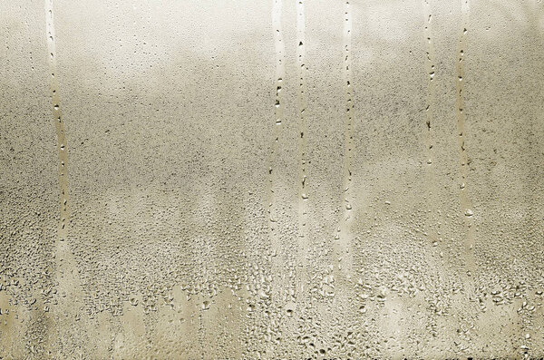 Texture of a drop of rain on a glass wet transparent background. Toned in yellow color