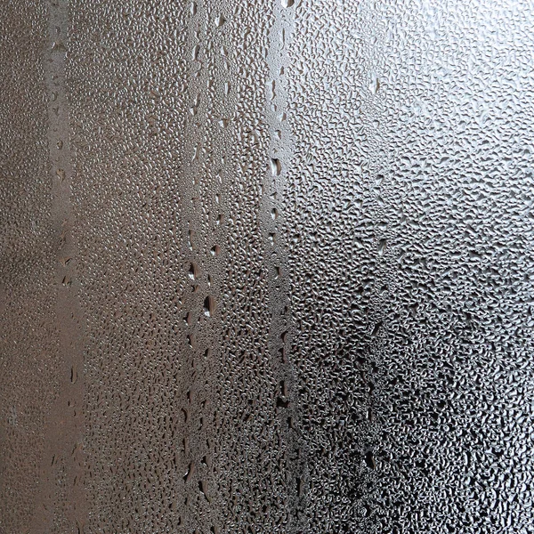 质地的一滴雨在玻璃湿透明的背景上 灰色色调 — 图库照片