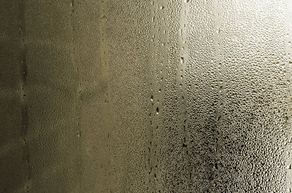 质地的一滴雨在玻璃湿透明的背景上 黄色色调 — 图库照片