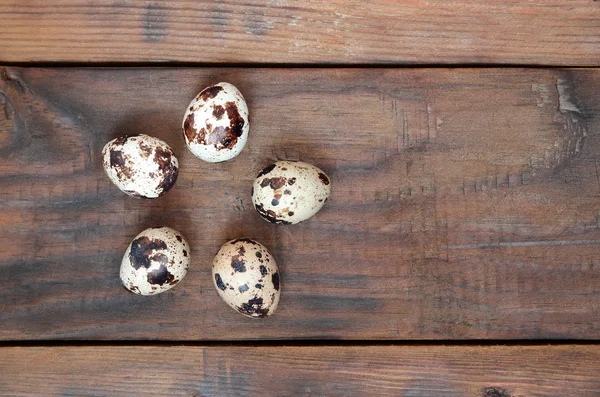 Jaja przepiórcze na ciemno brązowy powierzchni drewnianych, widok z góry, puste miejsce — Zdjęcie stockowe