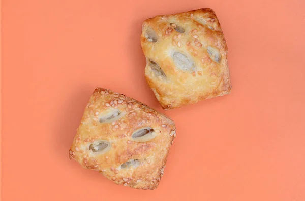 A satisfying meat patty, which combines an airy puff pastry and a delicate pork filling with onions. Baking on an orange background