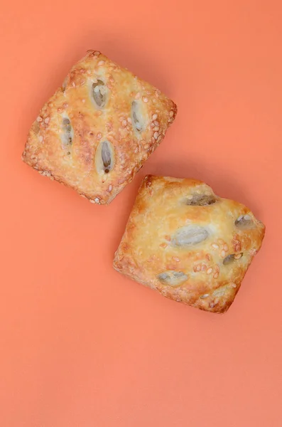 A satisfying meat patty, which combines an airy puff pastry and a delicate pork filling with onions. Baking on an orange background