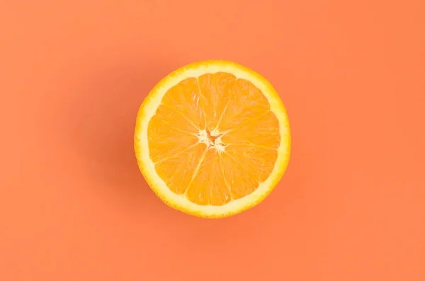 stock image Top view of a one orange fruit slice on bright background in orange color. A saturated citrus texture image