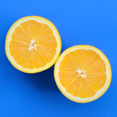 Mavi renkte parlak arka plan üzerinde üstten görünüm birkaç turuncu meyve dilimleri. Doymuş narenciye doku görüntü