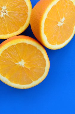 Mavi renkte parlak arka plan üzerinde üstten görünüm birkaç turuncu meyve dilimleri. Doymuş narenciye doku görüntü