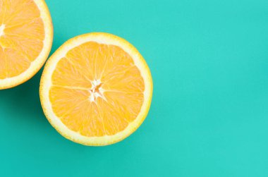 Turkuaz yeşil renkte parlak arka plan üzerinde üstten görünüm birkaç turuncu meyve dilimleri. Doymuş narenciye doku görüntü