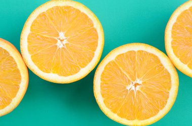 Turkuaz yeşil renkte parlak arka plan üzerinde üstten görünüm birkaç turuncu meyve dilimleri. Doymuş narenciye doku görüntü