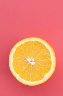 Kırmızı renkte parlak arka plan üzerinde üstten görünüm bir bir turuncu meyve dilim. Doymuş narenciye doku görüntü